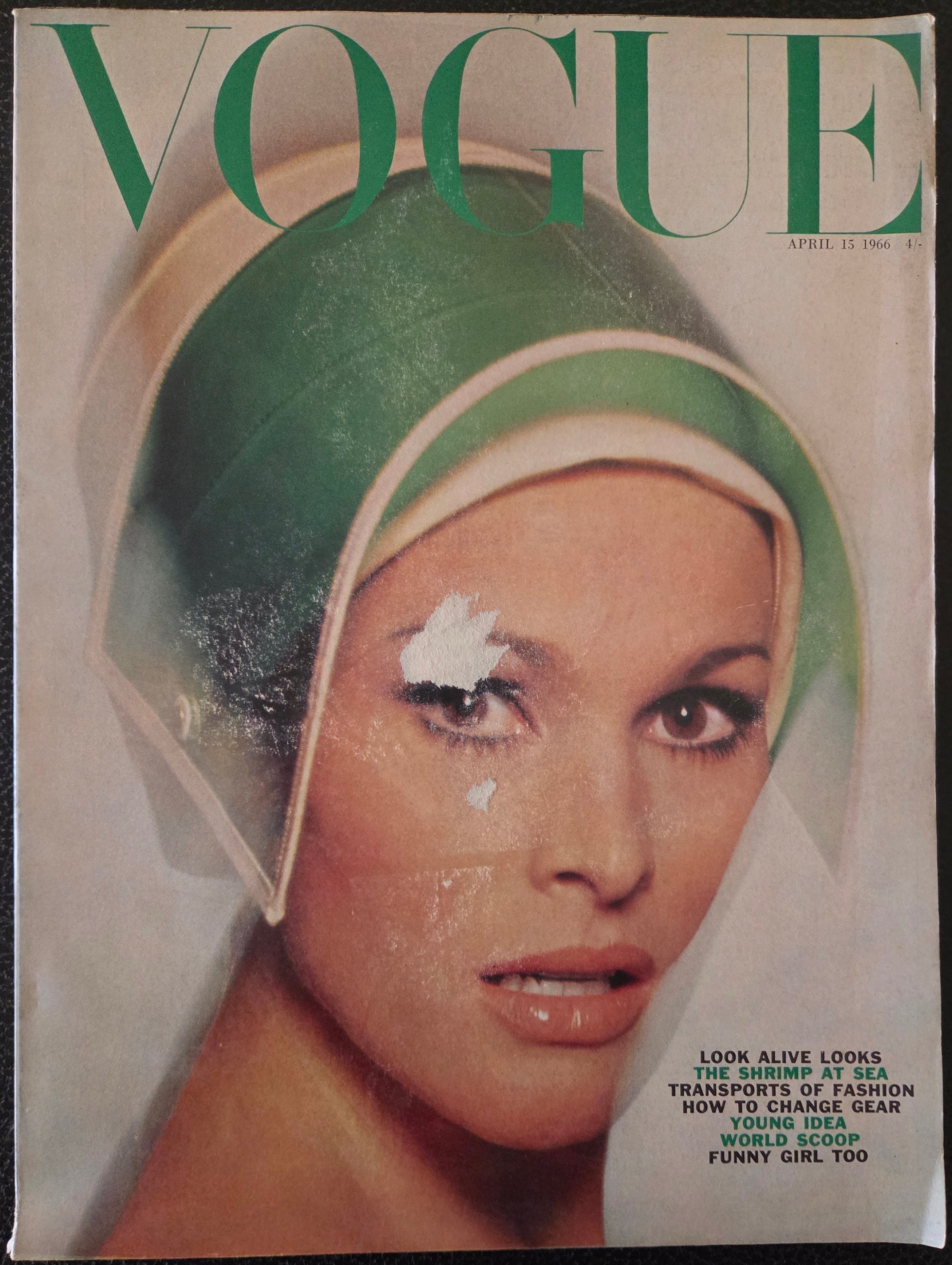 Vintage Vogue magazine cover with a model wearing a green visor like hat.
