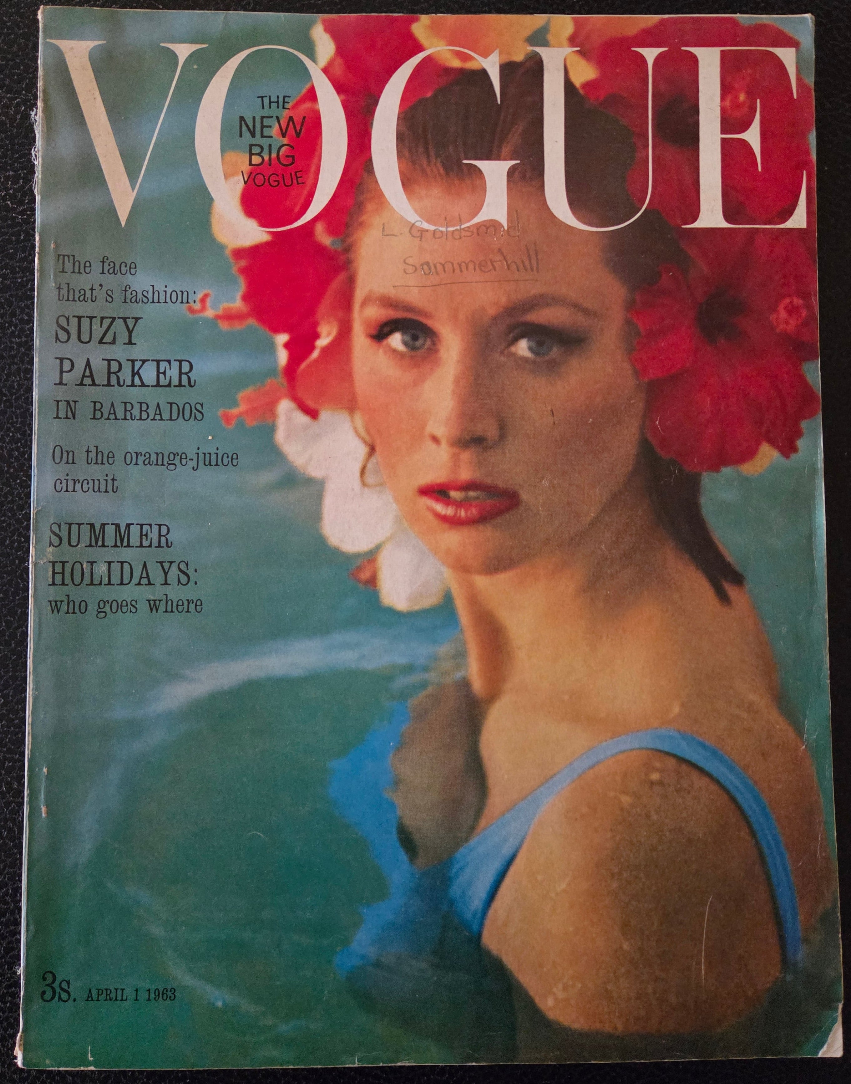 Vintage Vogue magazine cover with a woman in a blue bikini and red flowers.