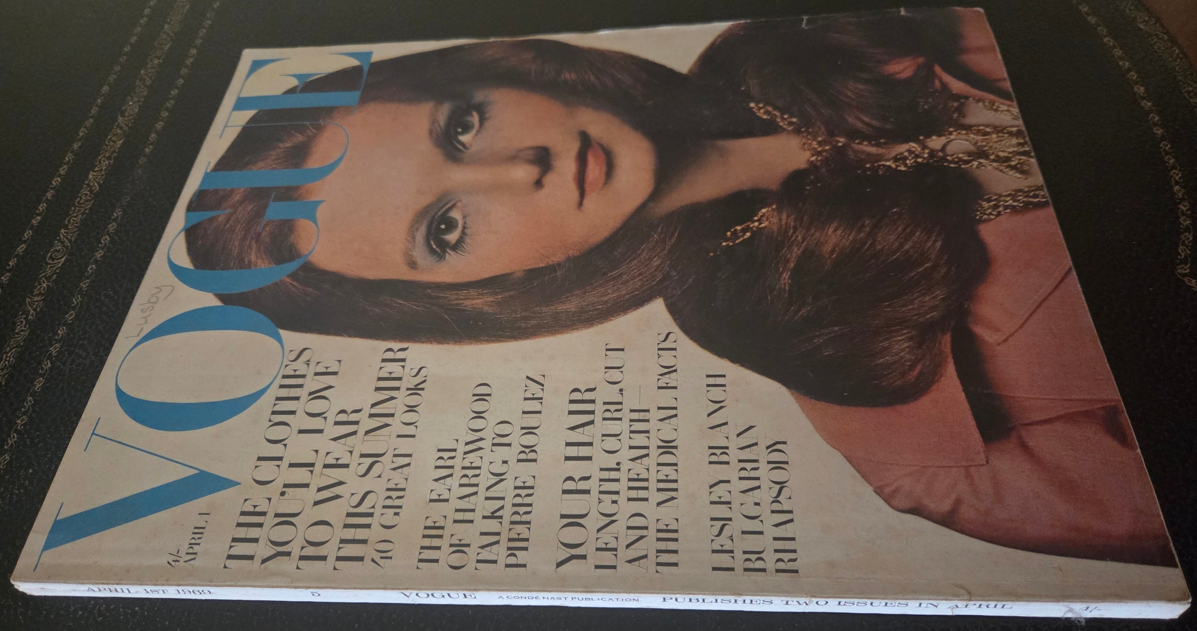 Vintage Vogue magazine cover with a woman's face on a dark background