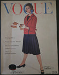 Vintage Vogue magazine cover with a woman in a red jacket and dark skirt.