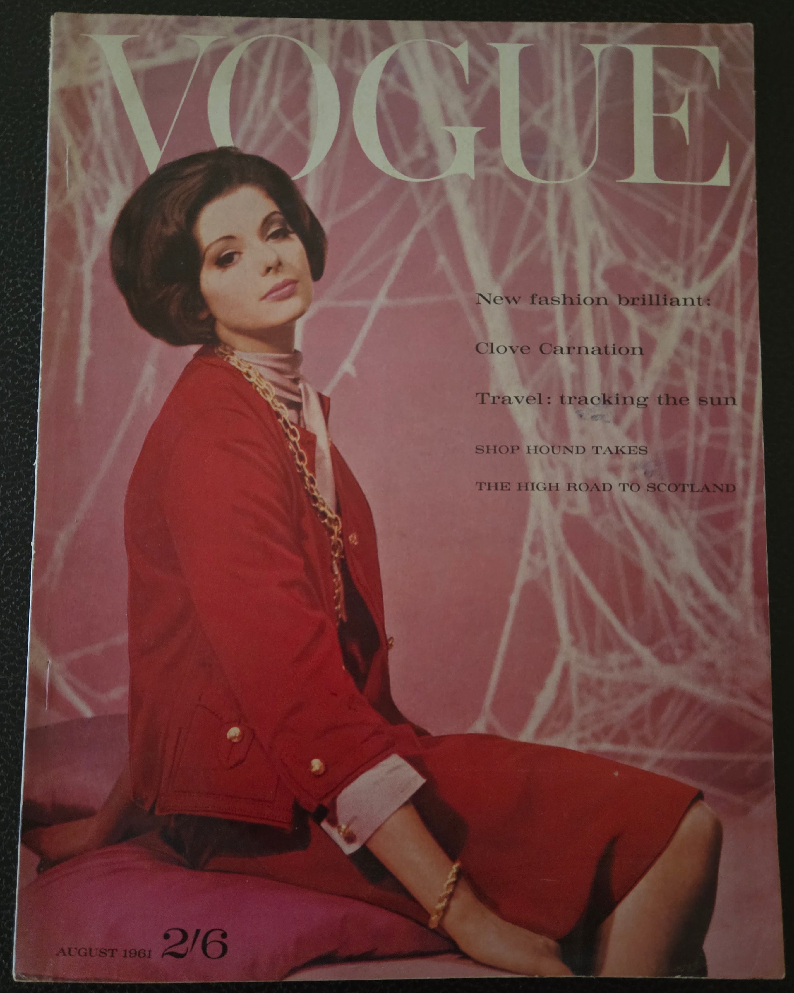 Vogue magazine cover with a model in a red outfit on a pink background