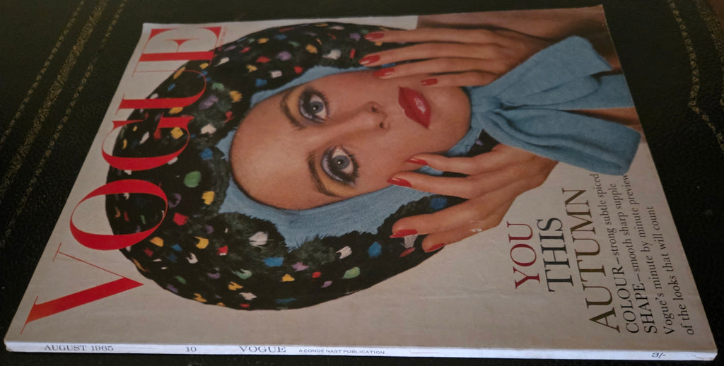 Vogue magazine cover with a model wearing a colorful headscarf and blue bow