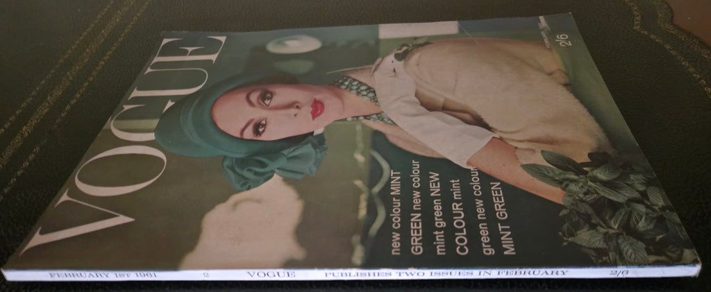 Vogue magazine cover with a model wearing a green headscarf on a dark surface