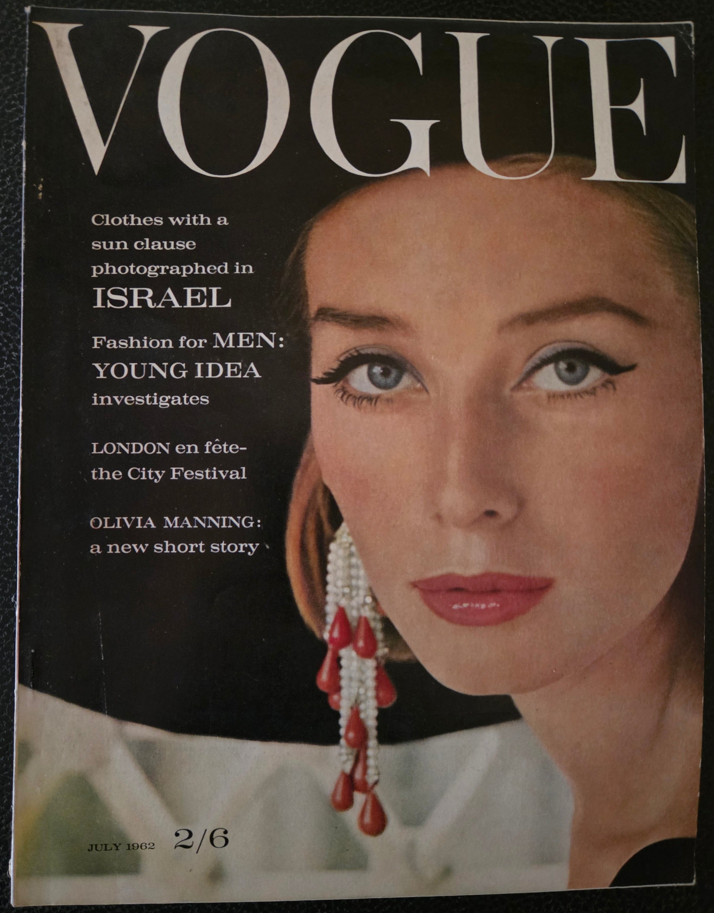 Vogue magazine cover with model wearing dark hat and diamond and red drop earrings.