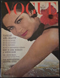 Vintage Vogue magazine cover with a woman's face and a flower, featuring text about fashion and beauty.