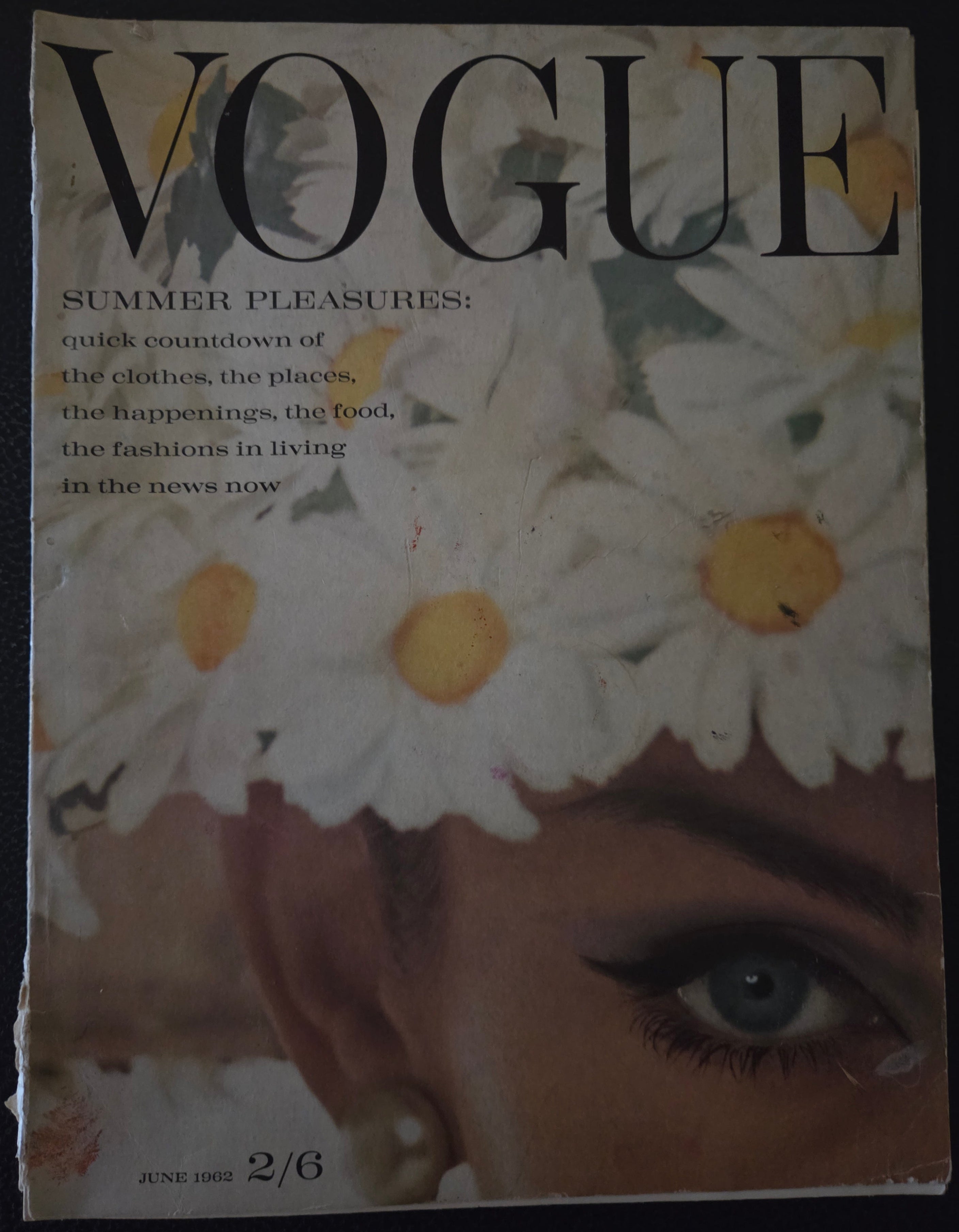 Vogue magazine cover with a woman's face and daisies