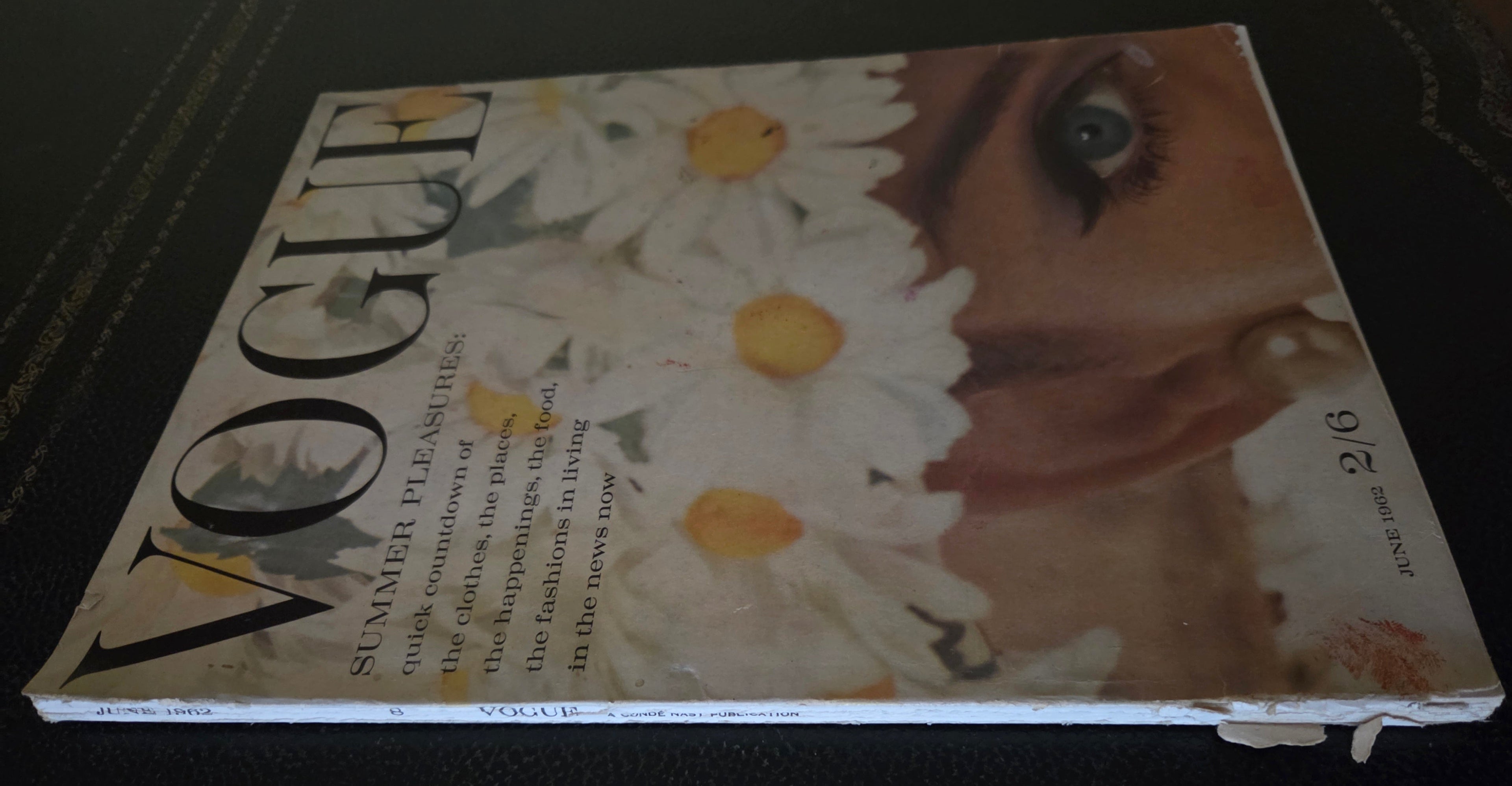 Vogue magazine cover with a woman's face and daisies