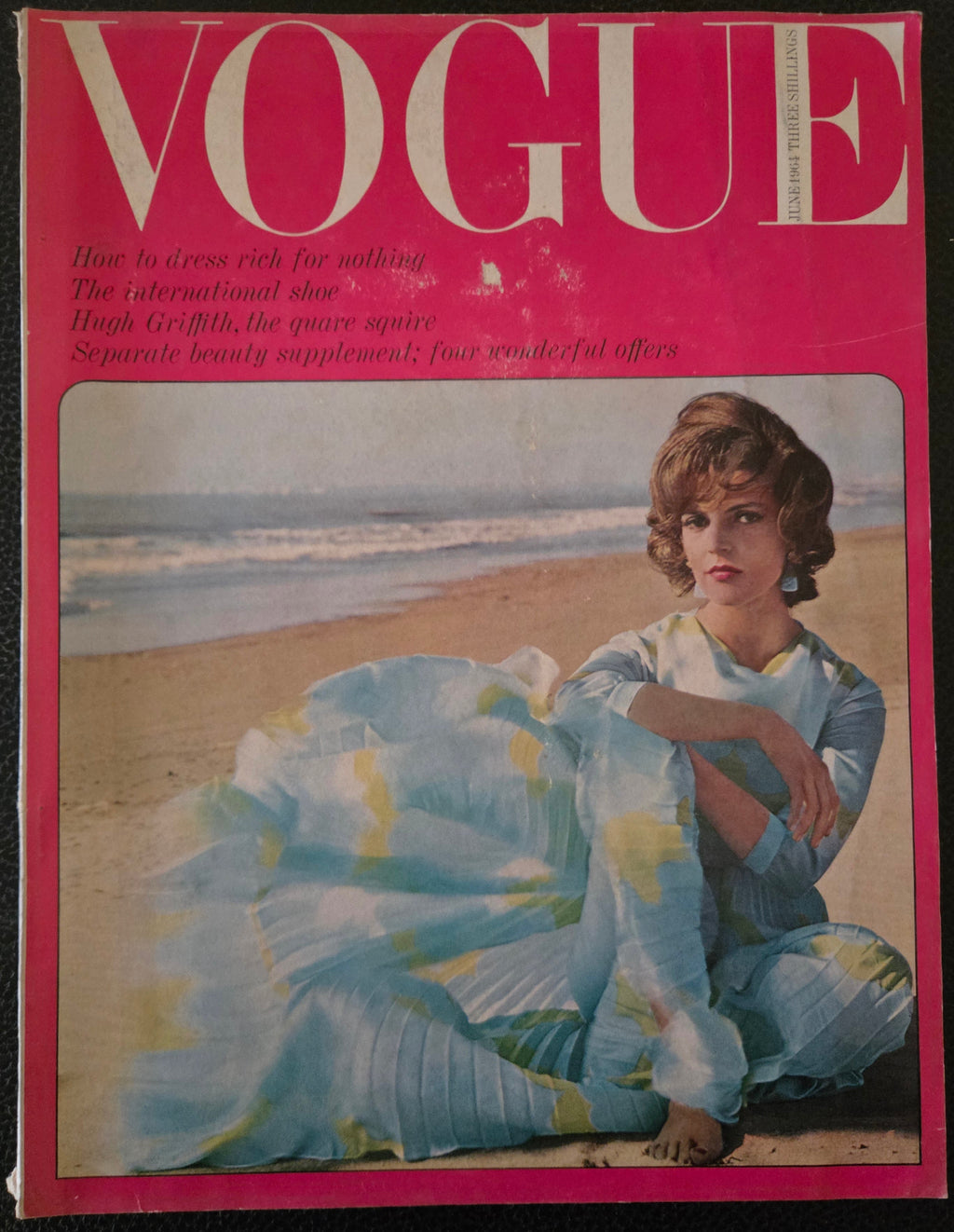 Vintage Vogue magazine cover with a woman in a blue dress on a beach