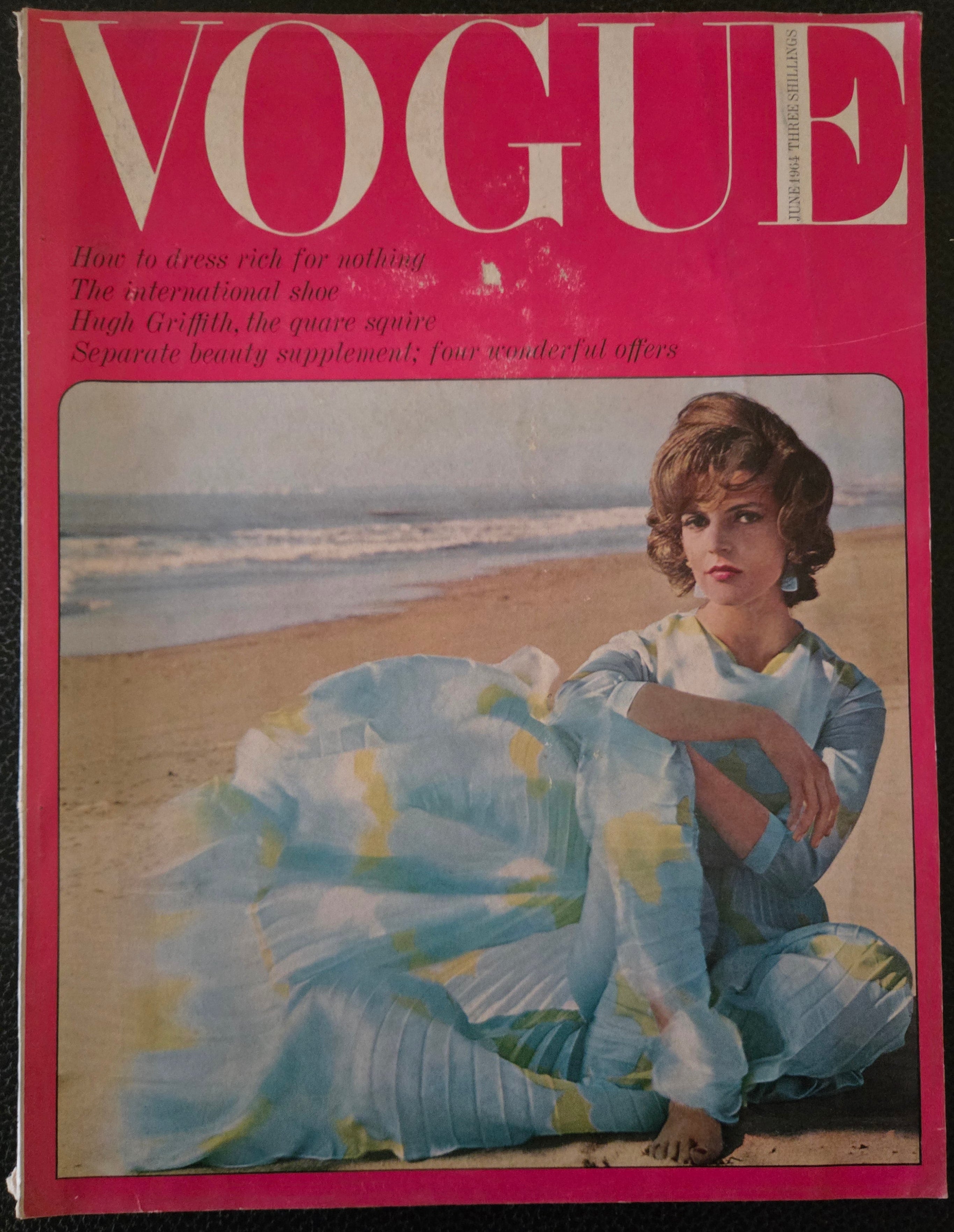 Vintage Vogue magazine cover with a woman in a blue dress on a beach