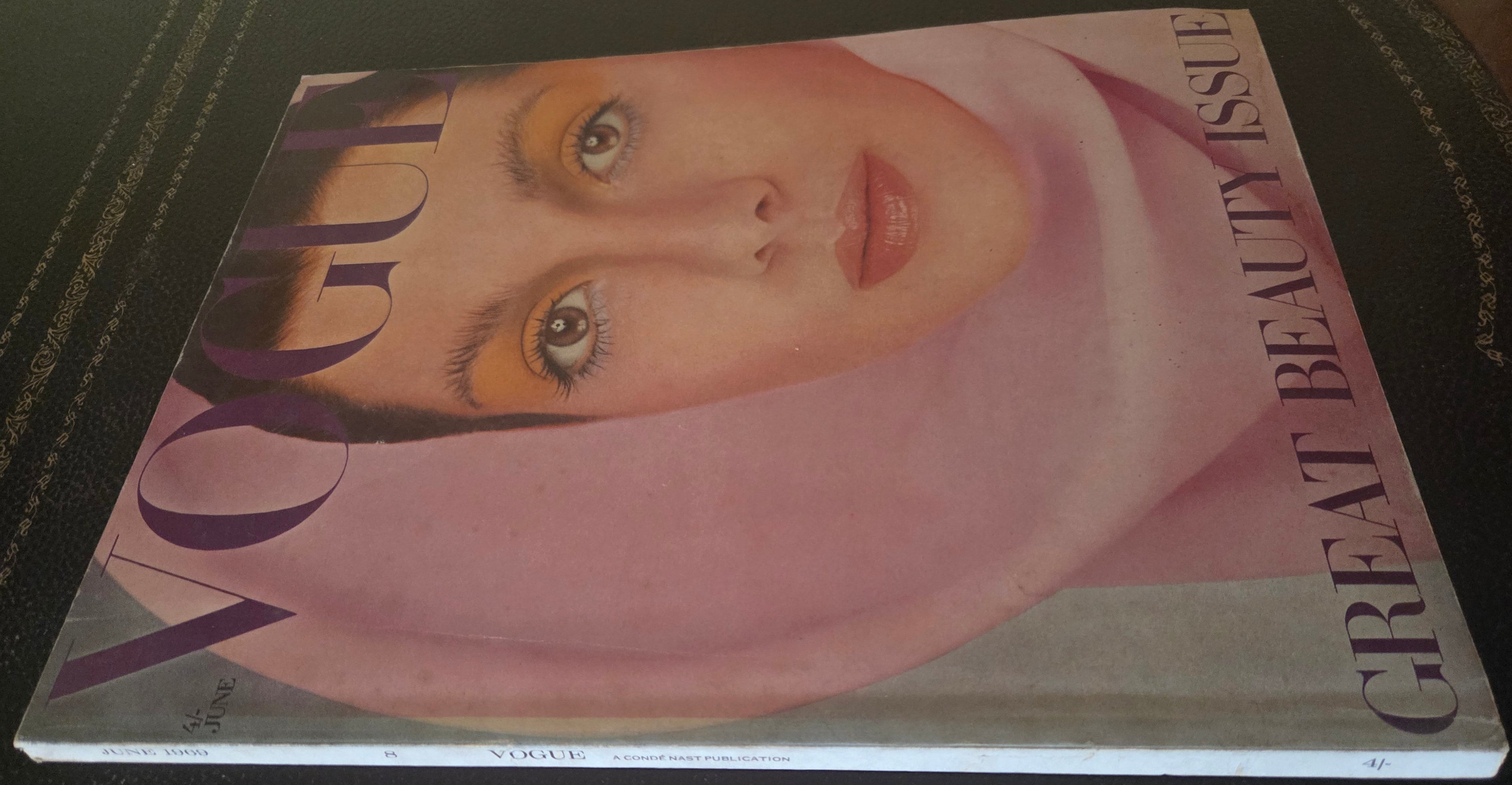 Vogue magazine with model in pink headscarf on cover.