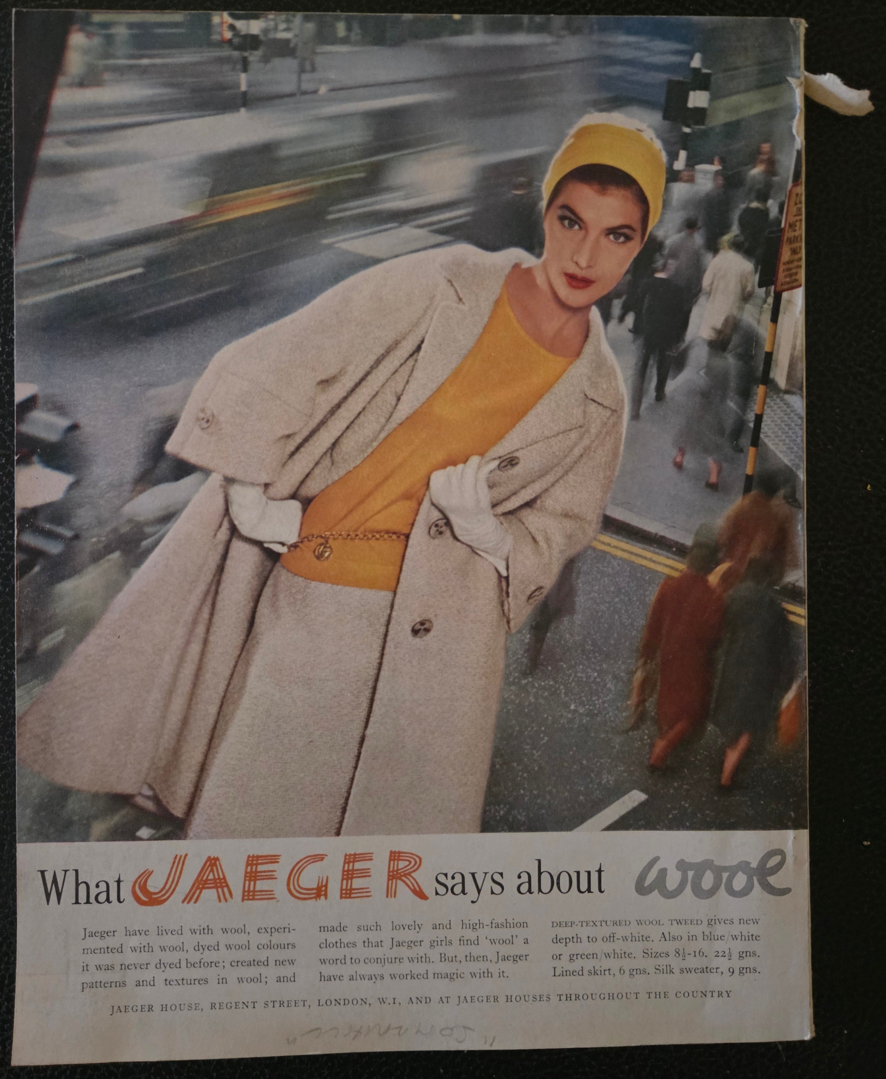Vintage advertisement featuring a woman in a Jaeger coat with a blurred city street in the background.
