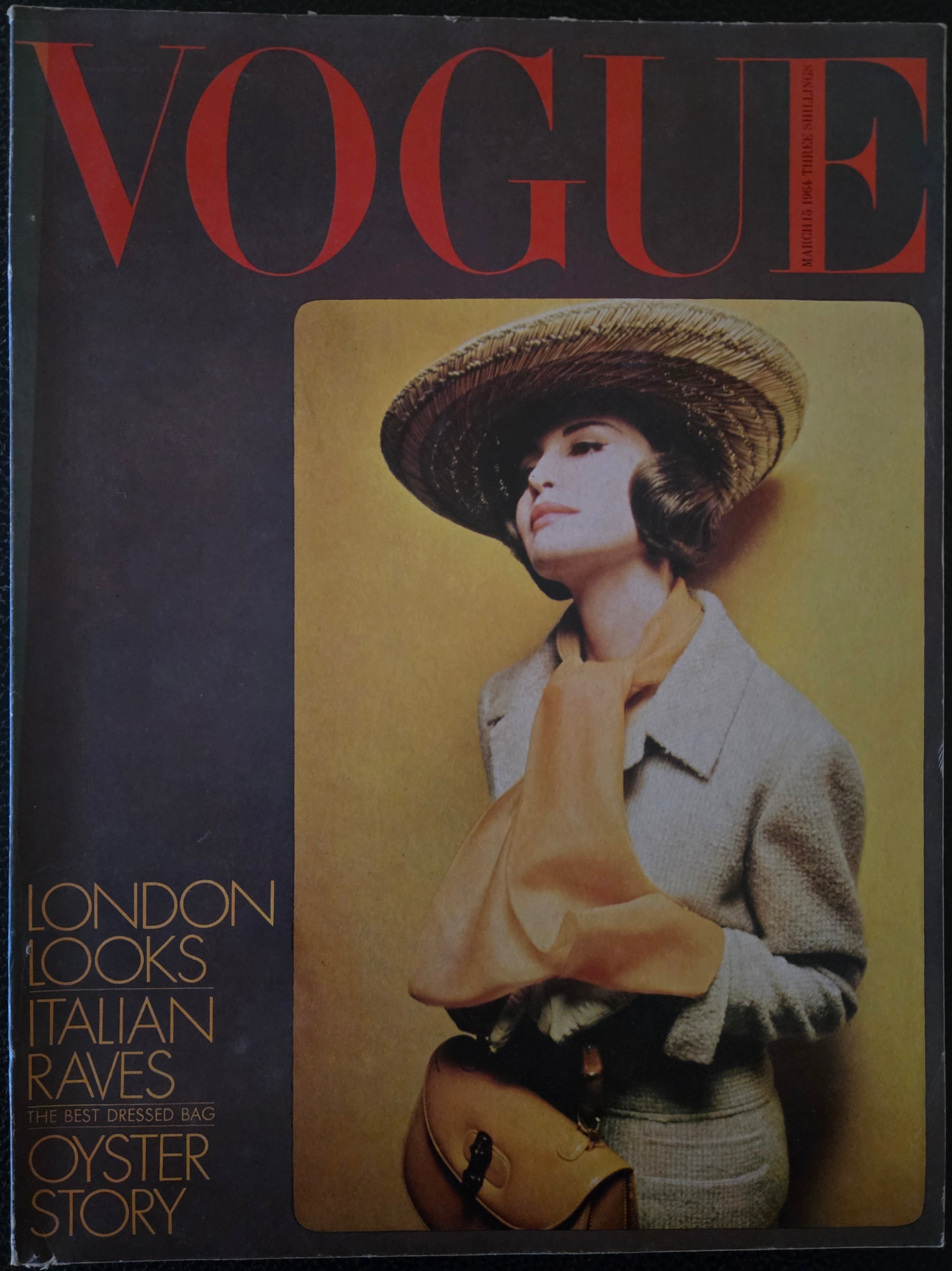Vintage Vogue magazine cover with a model wearing a hat and coat