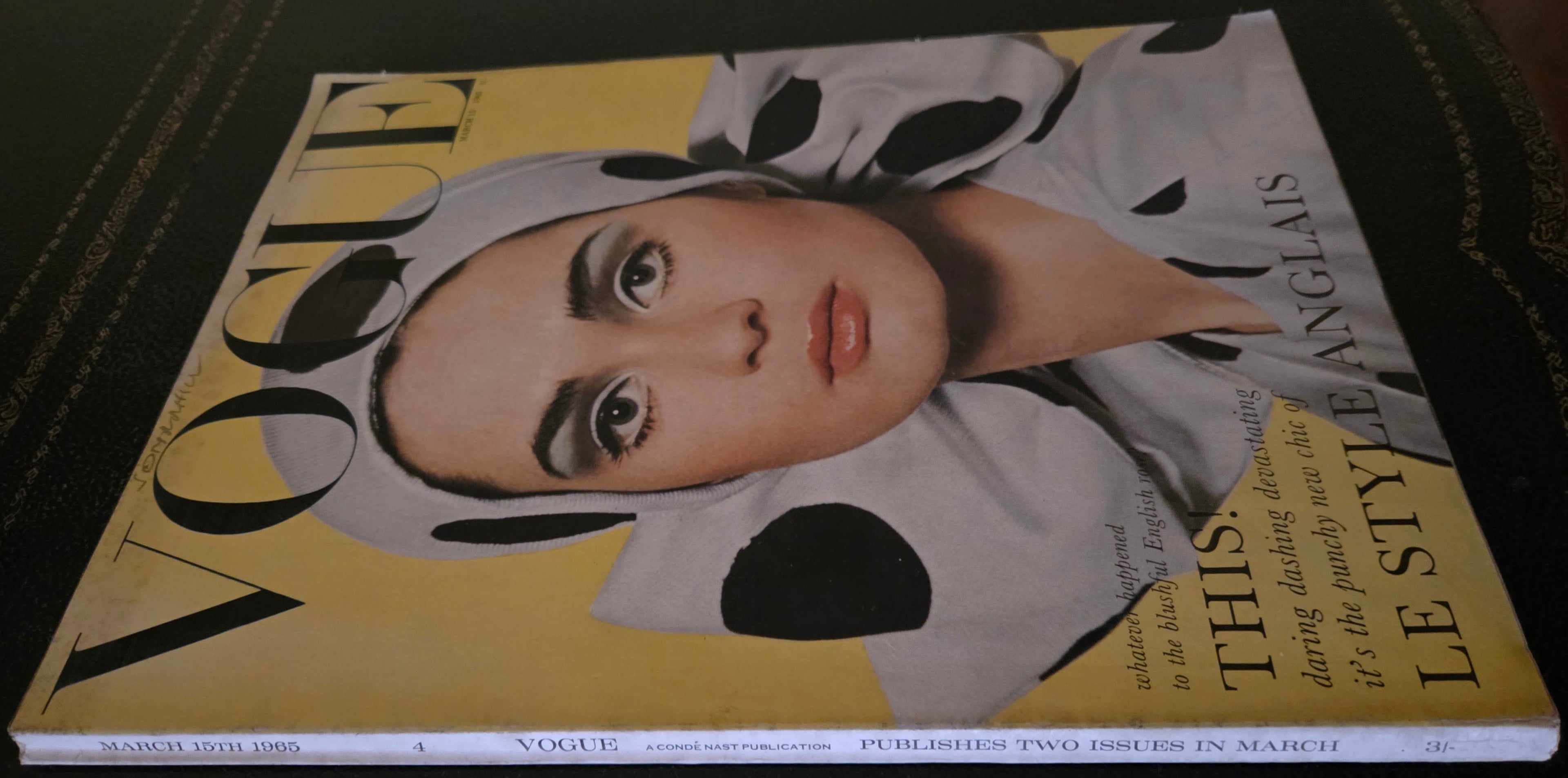 Vogue magazine with a cover featuring a model wearing a spotted outfit.
