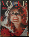 Vogue magazine cover with a stylized face design on a dark background