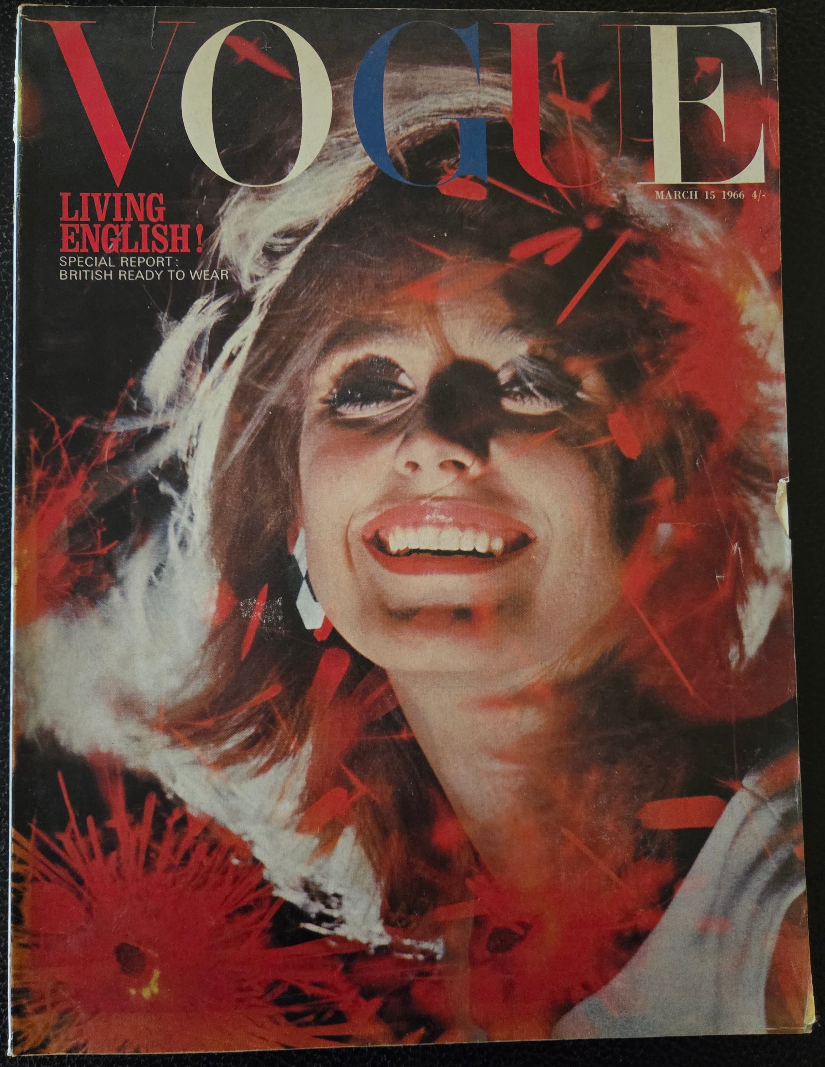 Vogue magazine cover with a stylized face design on a dark background