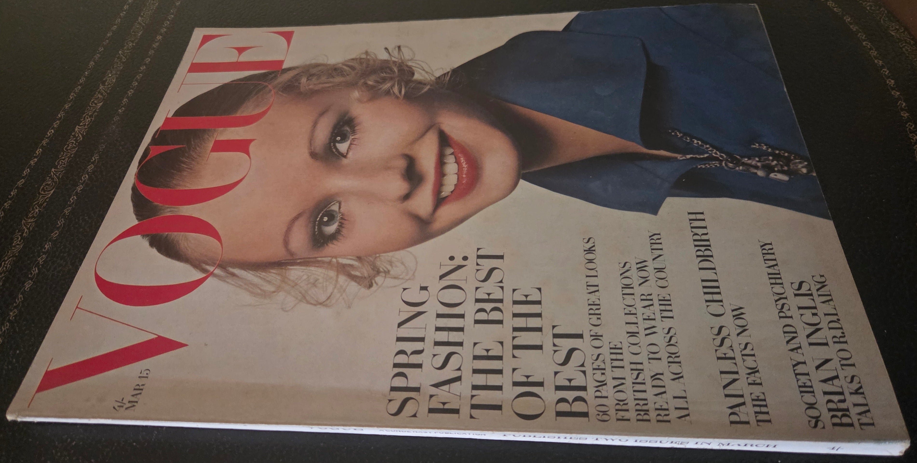 Vogue magazine cover with a woman's face on a dark surface