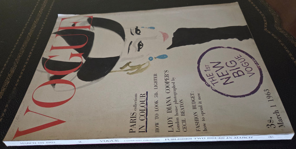 Vogue magazine cover with a stylized woman's face on a dark surface