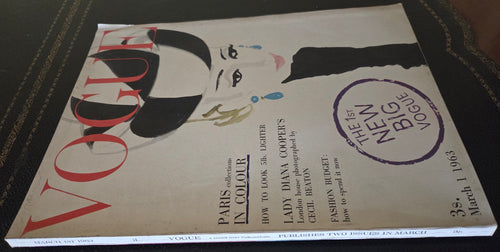 Vogue magazine cover with a stylized woman's face on a dark surface