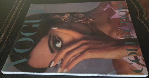 Vogue magazine cover with a model's face covered by hand.