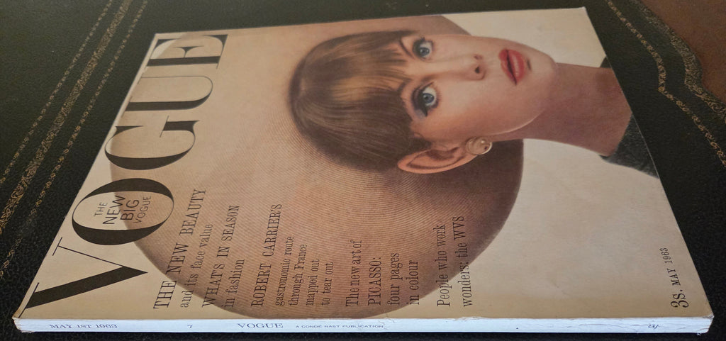 Vogue magazine cover with a model wearing a large hat.