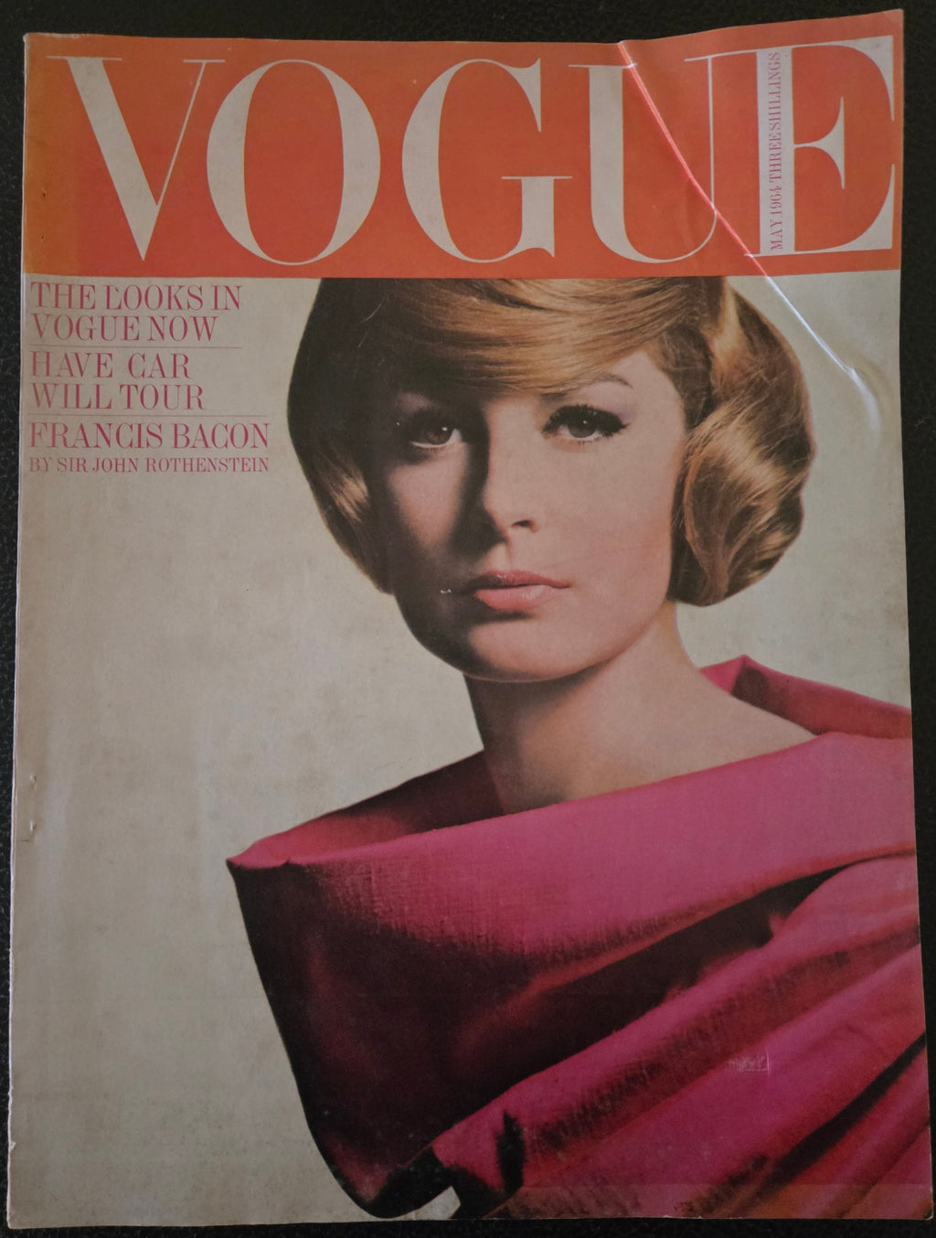 Vintage Vogue magazine cover with a woman in a pink outfit.