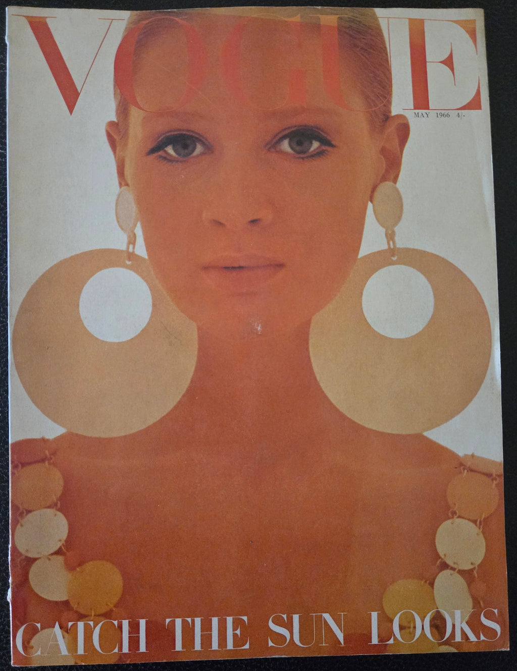 Vintage magazine cover with a woman's face and large circular earrings 