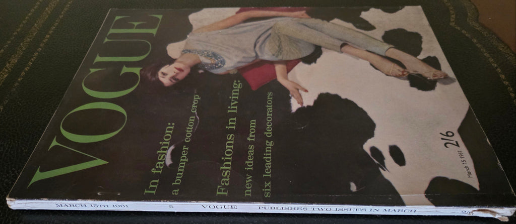 Vogue magazine cover with a model on a dark surface