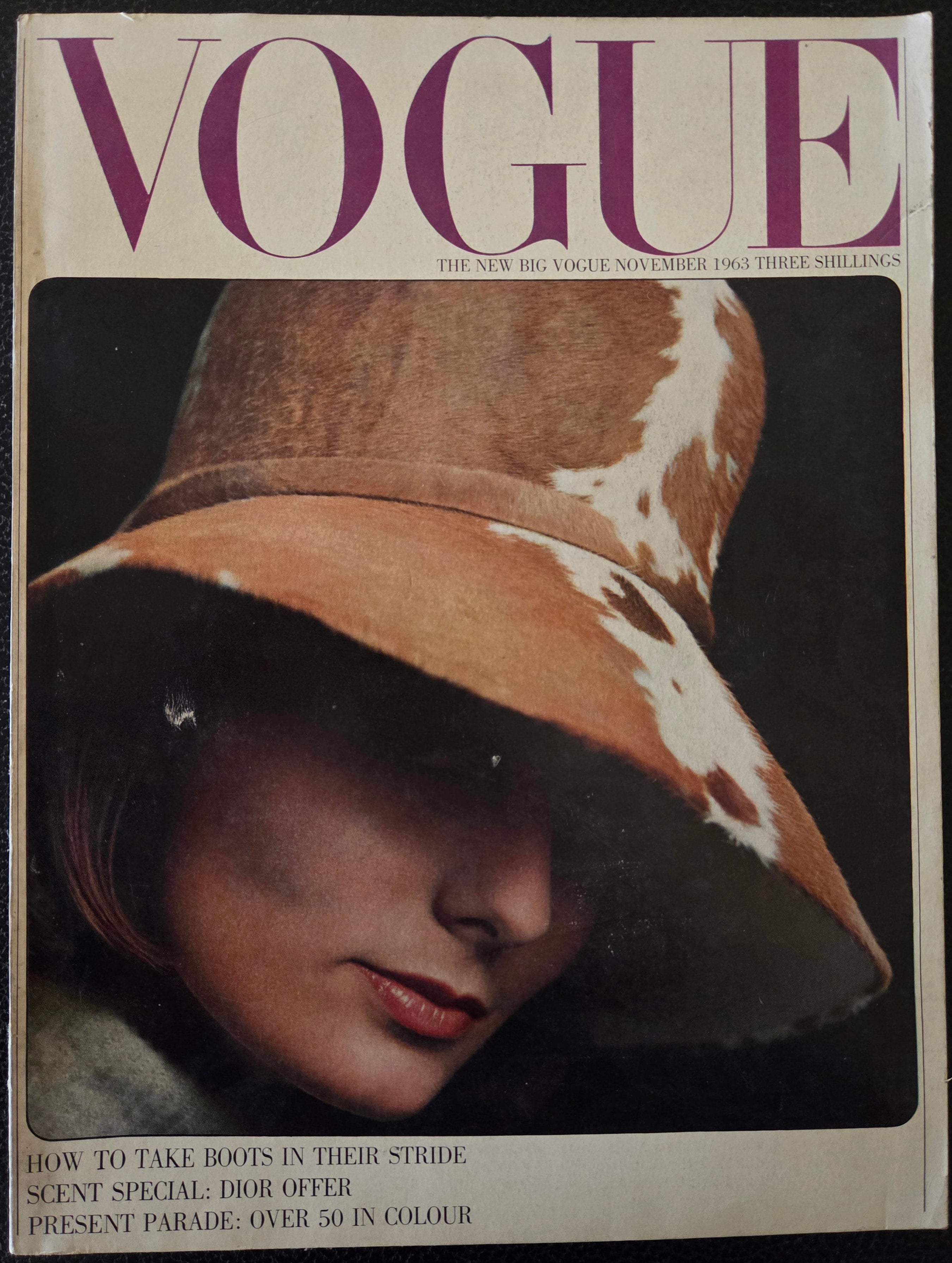Vintage Vogue magazine cover with a woman wearing a large hat.