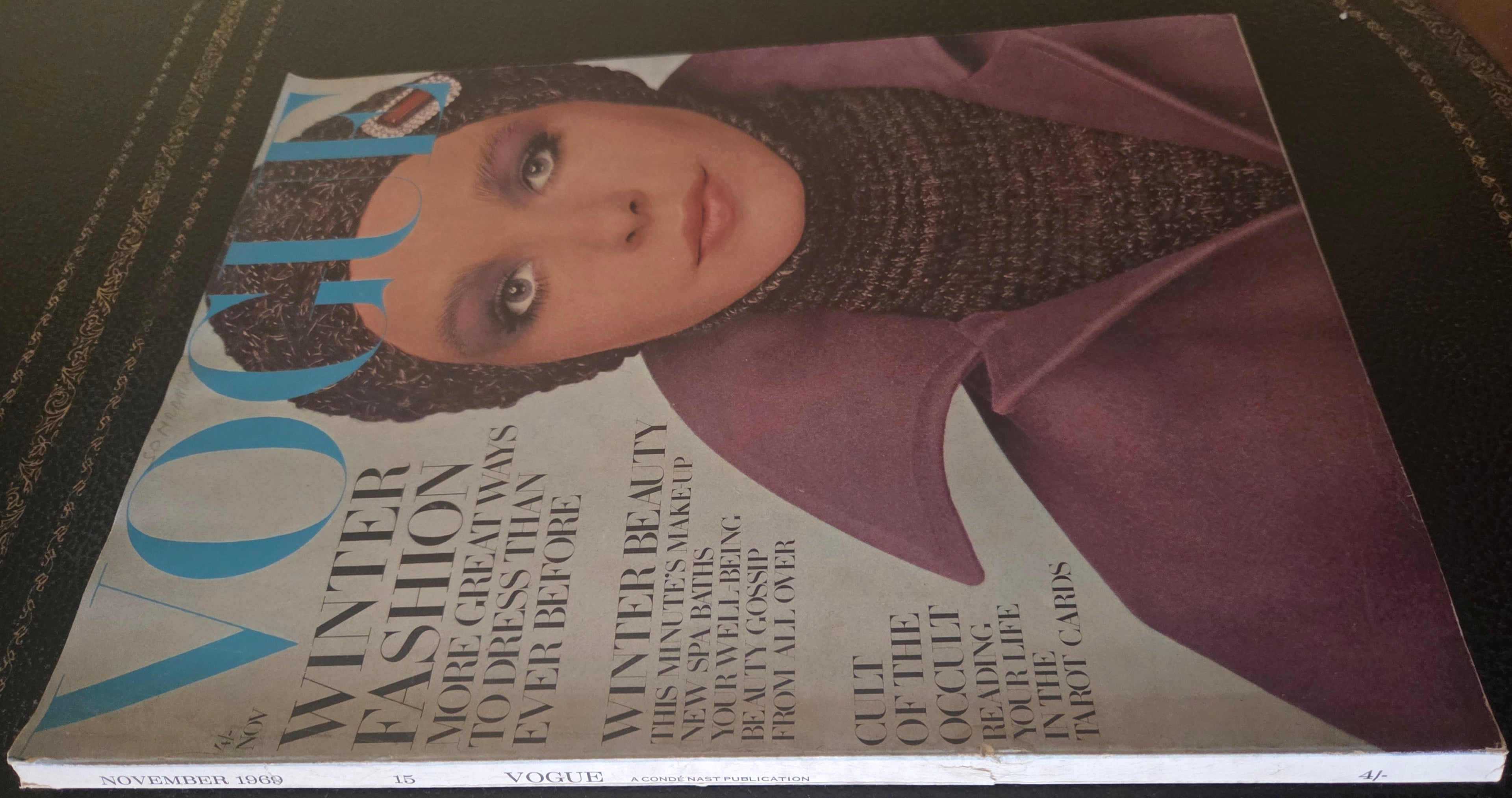 Magazine cover with a woman's face on a dark surface