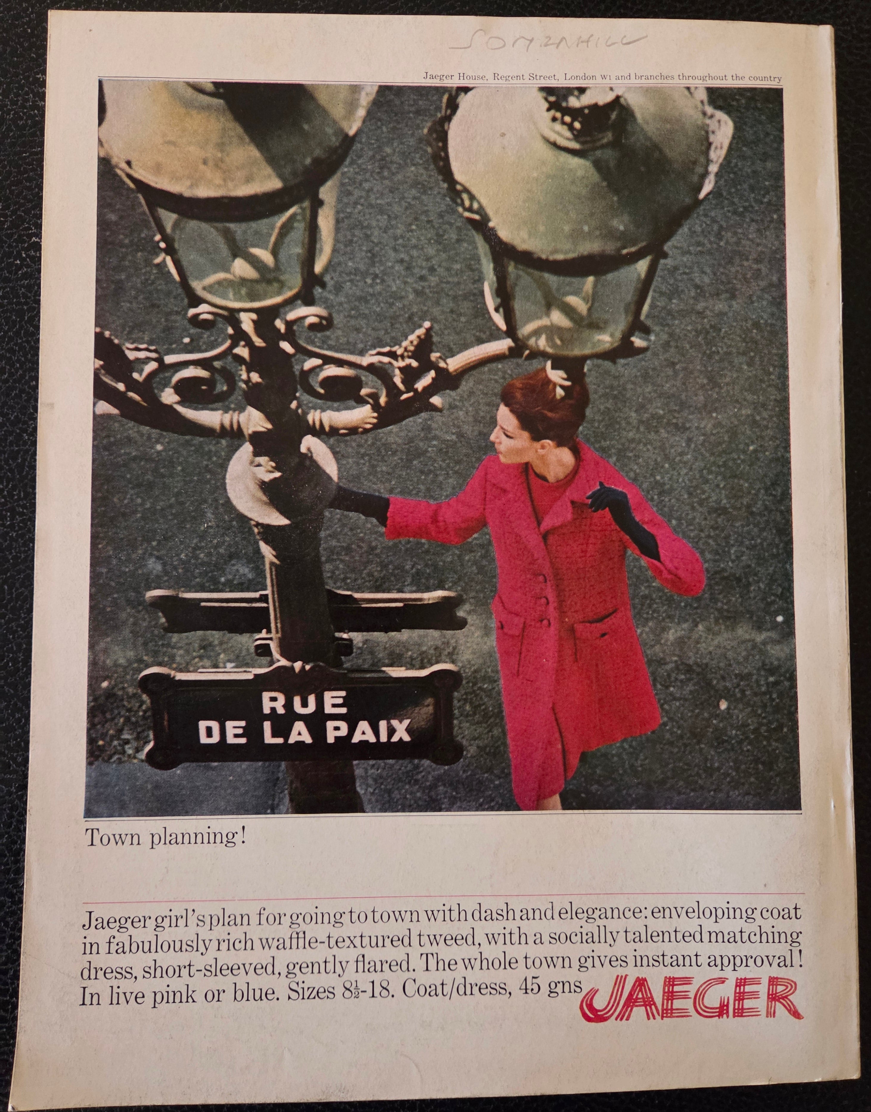 Vintage advertisement for Jaeger featuring a woman in a red coat by a lamp post.