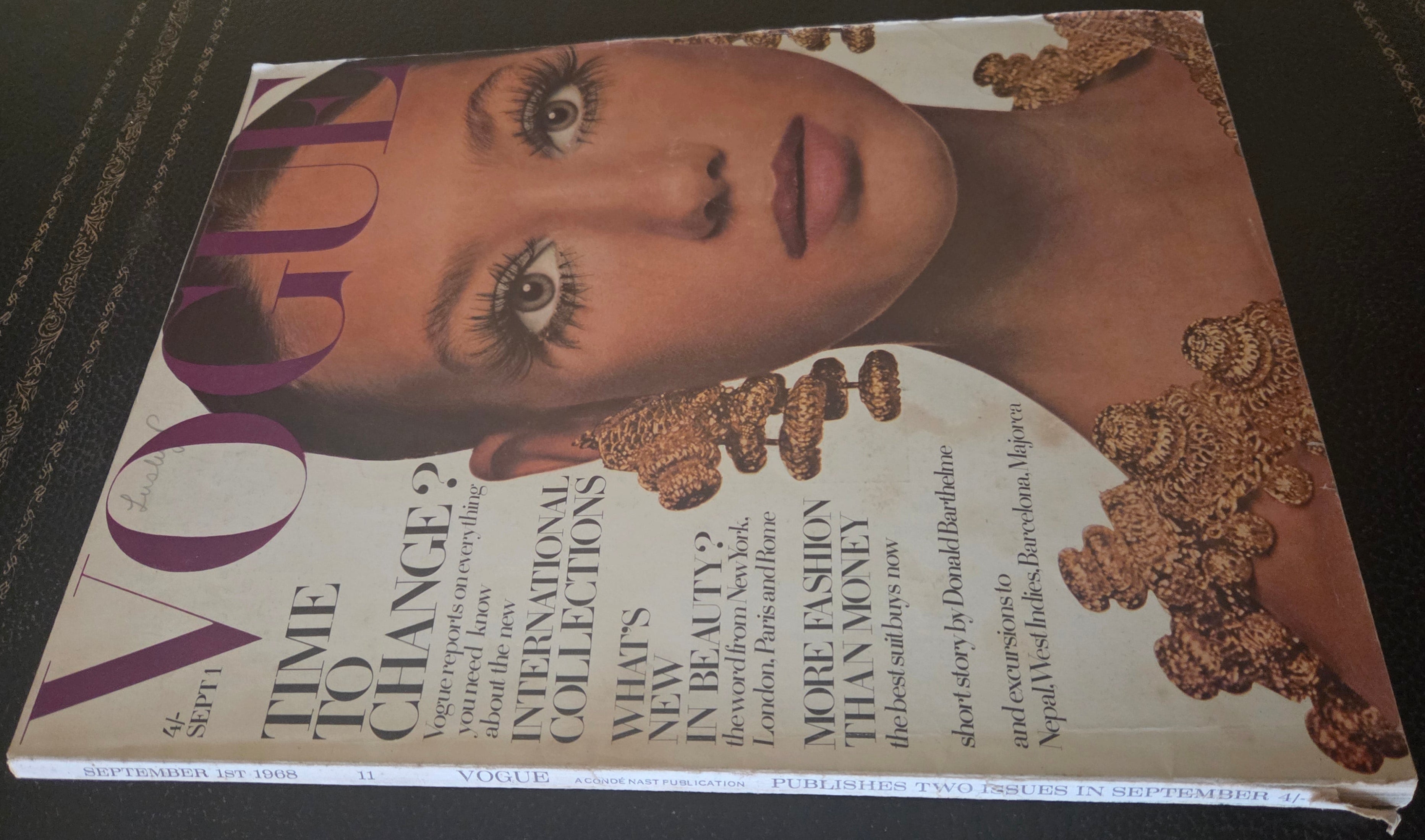Vogue magazine cover with a model's face and text on a dark surface