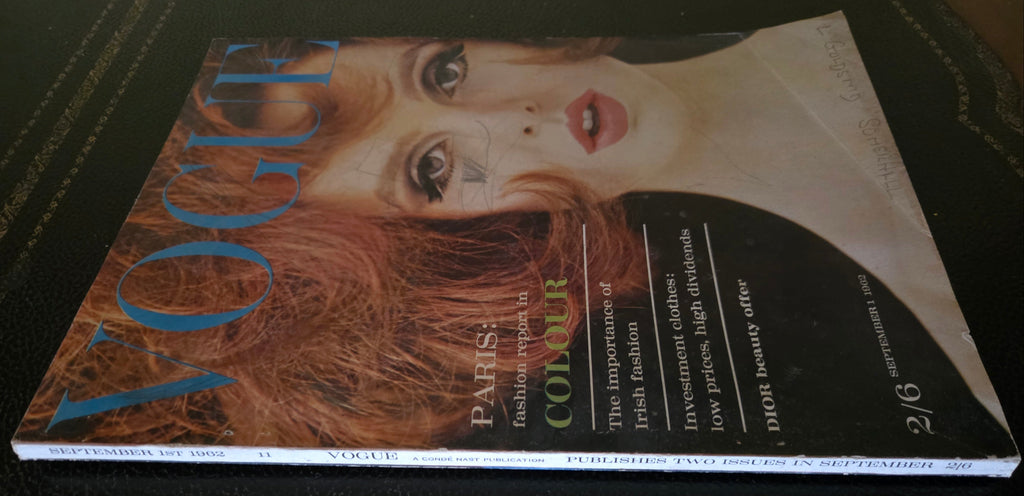 Vogue featuring model with red hair on dark background.