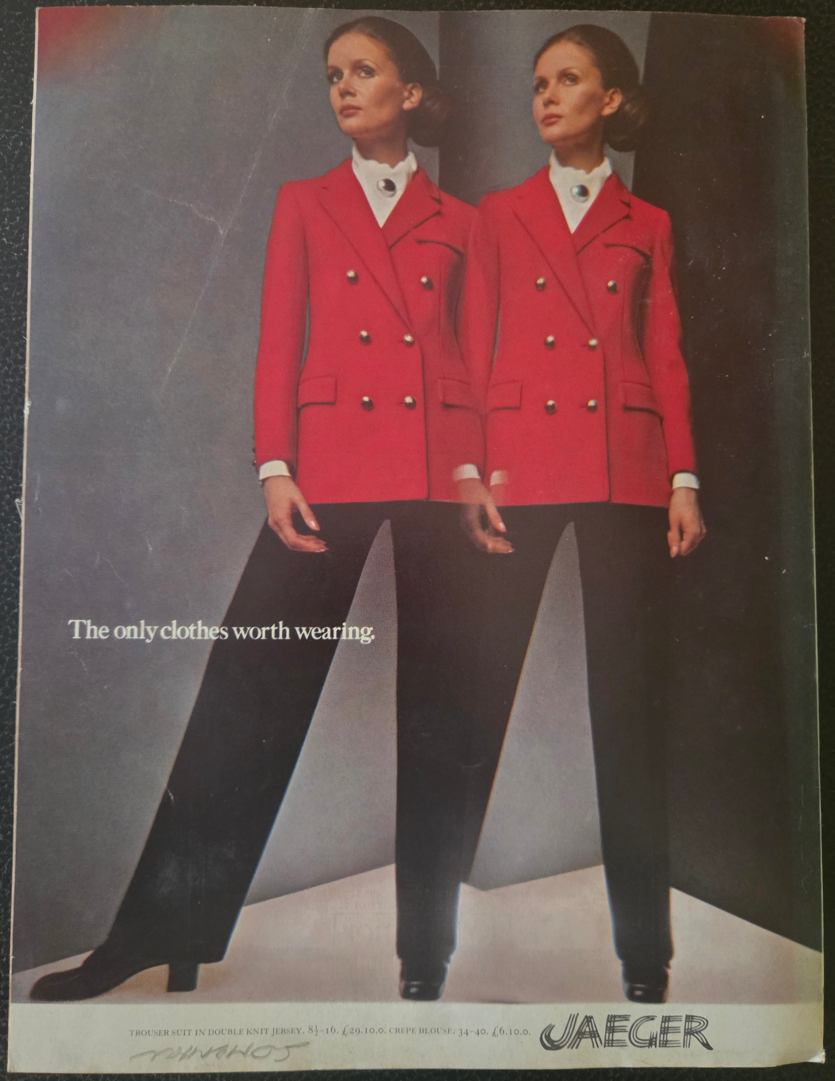 Vintage advertisement for Jaeger clothing featuring a red jacket and black pants.