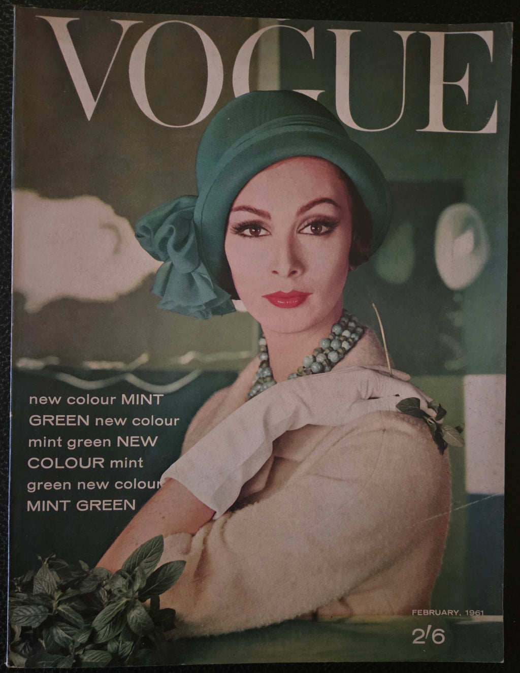 Vintage Vogue magazine cover with a model wearing a green headscarf and beige outfit.